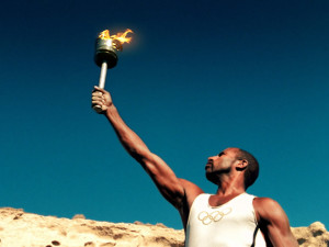 olympic-torch-flame-runner-hold-sky-modern-olympic-logo-t-shirt-african-olympian-photo